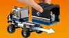 A hand is attaching a black and gray cargo container with a Jurassic World logo to a gray and blue LEGO truck. Produktbild-Vorschau