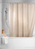 A beige shower curtain hanging in a bathtub with a shower head visible. Anteprima dell’immagine prodotto
