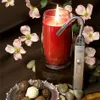 A red candle is lit with a lighter, surrounded by chocolates and flowers. Anteprima dell’immagine prodotto
