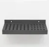 A dark gray shelf with many small circular indentations, mounted on a white wall. Produktbild-Vorschau