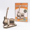 A wooden model of an electric guitar and amplifier set, displayed next to its packaging. Voir les images du produit