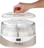 A hand is shown lifting the lid off a yogurt maker filled with yogurt jars. Anteprima dell’immagine prodotto