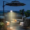An outdoor patio scene at dusk, featuring furniture, plants, and a floor lamp. Podgląd zdjęcia produktu