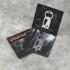 A survival keychain with 16 tools in one is displayed on a textured gray surface, partially open to reveal product details and the keychain itself. Produktbild-Vorschau