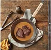 A de Buyer Mineral B frying pan with two steaks and sauce, served with french fries on a wooden table. Anteprima dell’immagine prodotto