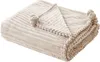 A folded beige blanket with a ribbed texture and pom-pom trim. Náhled obrázku produktu