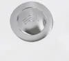 A close-up of a chrome drain cover with a footprint symbol on a white surface. Produktbild-Vorschau