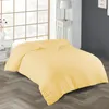 A yellow duvet is laid out on a bed in a bedroom setting. Produktbild-Vorschau