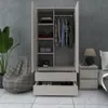 A modern wardrobe with open doors, displaying clothes and shelves, next to a beanbag chair and a nightstand with a lamp. Produktbild-Vorschau
