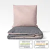 A folded duvet and pillow with certification labels. Produktbild-Vorschau