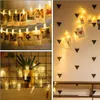 A collage of three images showing string lights with clips holding photos, decorations, and a plant. Produktbild-Vorschau