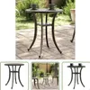A collage of images showing a round outdoor table with a decorative pattern on top and curved legs. The main image shows the table on a paved patio with greenery in the background. Two smaller images show the table from different angles, one with chairs an Náhled obrázku produktu