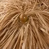 A close-up view of the top of a straw umbrella, showing the central mechanism and the straw material. Voir les images du produit
