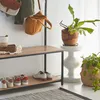 An entryway with a shoe rack, bags hanging on a rack, and plants. Anteprima dell’immagine prodotto
