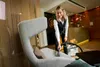 A woman is cleaning a chair with a vacuum cleaner attachment. Anteprima dell’immagine prodotto