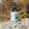 Weißer Kletterbecher von YY Vertical mit grünem Klettergriff auf einem Felsen im Freien. Podgląd zdjęcia produktu