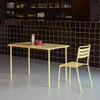 A yellow metal table and chair set is placed in front of a black tiled wall. Anteprima dell’immagine prodotto