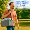 A man is walking outdoors in a park, carrying a cooler bag over his shoulder. The background shows trees and a sunny sky. Produktbild-Vorschau