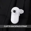 A white camera is clipped to a black backpack strap. Náhled obrázku produktu