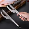 A hand holding a fish scaler with a fish in the background. Náhled obrázku produktu