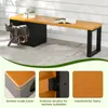 A grey cat is walking out of a black cat house integrated into a wooden bench. The bench has a wooden top and black metal legs. There are plants on the bench and an open book. The scene is set outdoors on a patio. Voir les images du produit