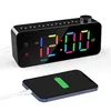 A digital alarm clock is shown with a smartphone charging next to it. Produktbild-Vorschau