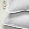 A close-up view of two white pillows, with a logo and text overlay on the left side. Produktbild-Vorschau
