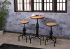 A bar table and two bar stools are set up in a room with a stone wall and a window. Produktbild-Vorschau
