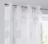 A close-up view of a white sheer curtain with a printed circular pattern in pink and gray, hanging on a curtain rod. Produktbild-Vorschau