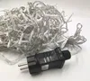 A tangled pile of white LED string lights with a black power adapter in the foreground, on a white background. Produktbild-Vorschau