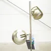 A close-up shot of a modern metal floor lamp with two spherical lampshades. Produktbild-Vorschau