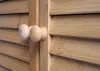 A close-up view of two wooden knobs on a bamboo cabinet door. Produktbild-Vorschau