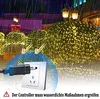 A nighttime scene with bushes decorated with warm white LED lights, under heavy rain. A close-up of an electrical plug and socket is overlaid, with a warning about water protection. Náhled obrázku produktu