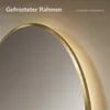 Close-up of a round mirror with a gold frame and LED lighting. Produktbild-Vorschau
