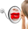 A woman is applying red lipstick while looking into a lighted makeup mirror. Podgląd zdjęcia produktu