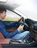 A man driving a car with a phone mounted on the dashboard. Podgląd zdjęcia produktu