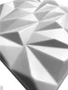 A close-up, angled view of a white, geometric wall panel with a textured surface. Náhled obrázku produktu
