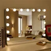 A vanity mirror with LED lights on a dresser, with some makeup items and books. Produktbild-Vorschau