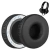 Two black ear pads for headphones are shown, with one slightly behind the other. A pair of black headphones is visible in the upper right corner. Produktbild-Vorschau
