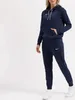A woman wearing a navy blue Nike tracksuit. Anteprima dell’immagine prodotto