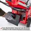 A gloved hand is inserting a mulch kit into a lawnmower. Produktbild-Vorschau