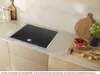 A modern kitchen countertop with an induction hob, cutting board with vegetables and nuts, and kitchen utensils. Podgląd zdjęcia produktu