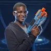 A young person wearing safety glasses holds a blue and orange toy gun. Anteprima dell’immagine prodotto