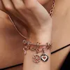 A close-up shot of a person's wrist wearing multiple Pandora charm bracelets. Produktbild-Vorschau