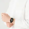 A person wearing a white shirt and a black digital watch. Náhľad obrázku produktu