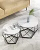 A set of two round coffee tables with marble-effect tops and geometric black metal bases, placed on a textured rug next to a beige sofa. Náhled obrázku produktu
