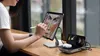 A person is using a tablet and a charging station with multiple devices. Anteprima dell’immagine prodotto
