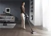 A woman is vacuuming a wooden floor in a modern living room. Produktbild-Vorschau