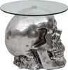 A silver skull-shaped side table with a glass top, presented against a white background. Podgląd zdjęcia produktu