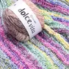 A close-up of a ball of YarnArt Dolce Vita yarn with a colorful knitted fabric in the background. Produktbild-Vorschau